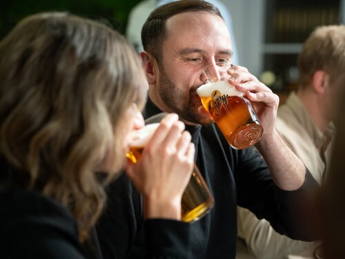 Ein Mann und eine Frau genießen gemeinsam ein Bier in geselliger Runde.