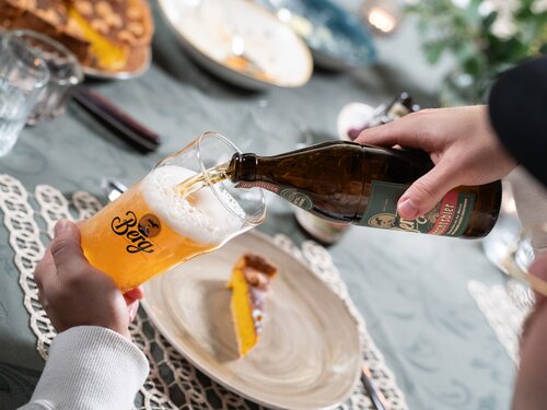 Eine Person gießt Bier in ein Glas.