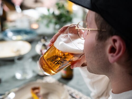 Ein Mann genießt ein Bier in einer entspannten Umgebung.